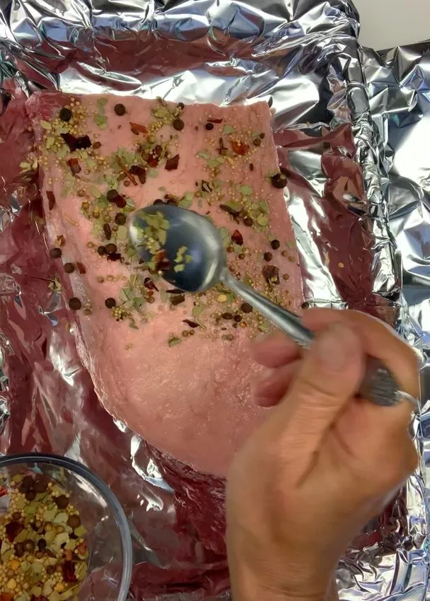 Sprinkling pickling spice over the brisket