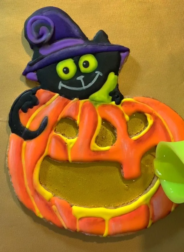 Melted isomalt is poured into the cutout windows of the cookie.
