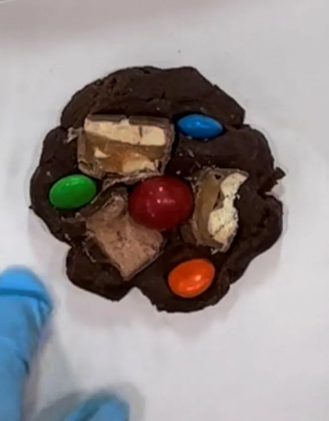 Cookie dough topped with peanut butter cup pieces and M&Ms