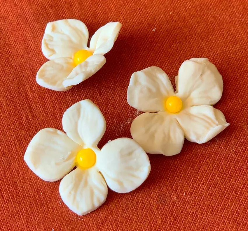 Small white fondant flowers made with a petal punch