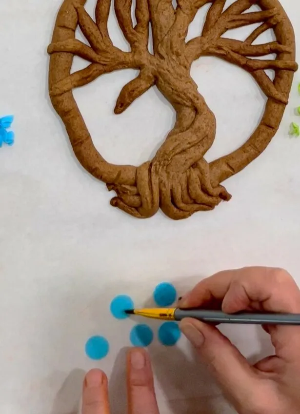 Punching circles from colored wafer paper with a paper punch.