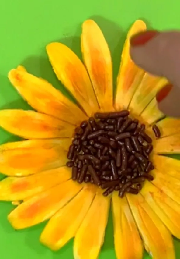 Gumpaste sunflower with chocolate sprinkles in the center.
