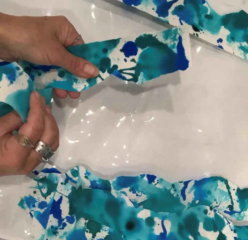 Ripping colored edible paper into strips.