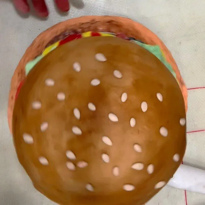 Small white fondant sesame seeds placed on the top bun.
