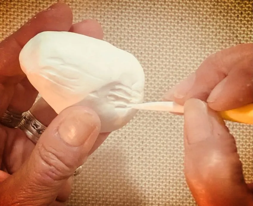 Shaping white modeling chocolate into a cone for the body.
