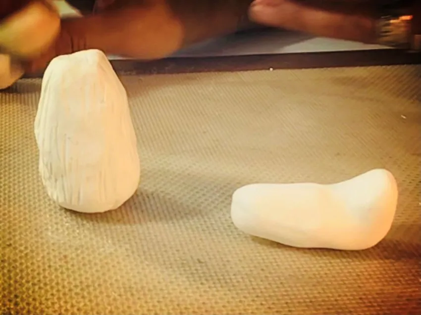 Shaped pieces of white modeling chocolate for legs.