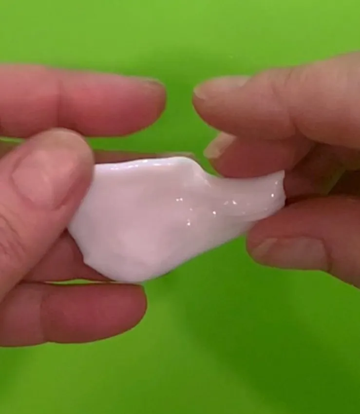 Hands shaping isomalt into the swan body shape.