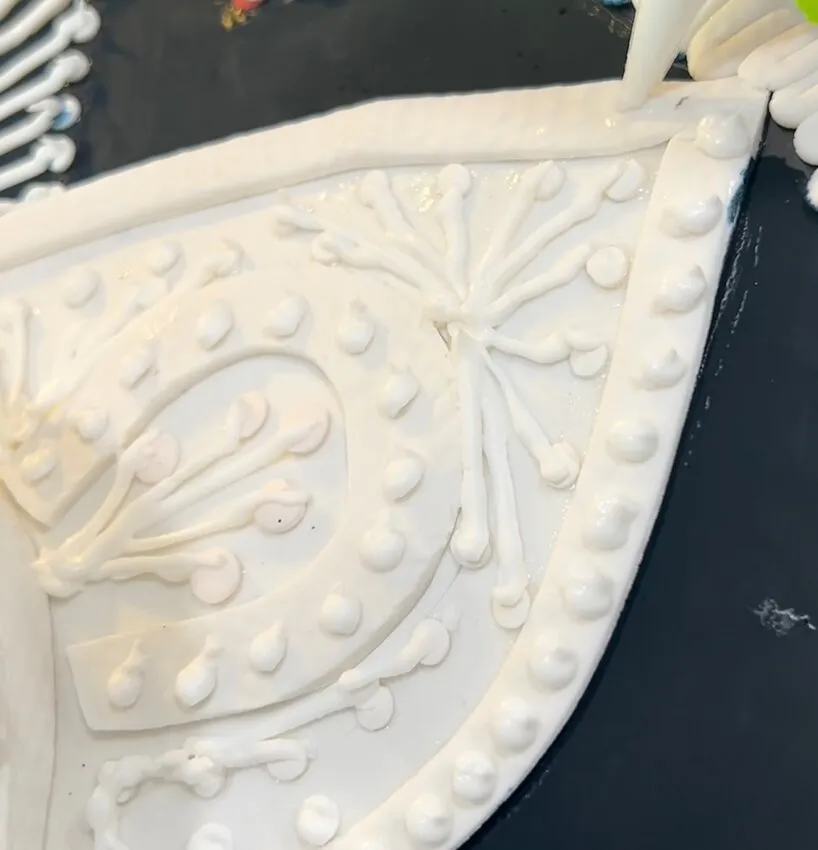 Piping decorative icing patterns on the hat