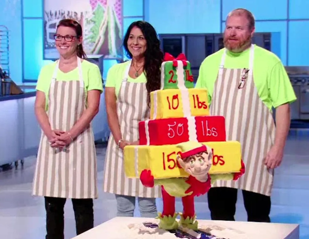 An elf-themed tiered cake on Cake Wars Christmas stocking stuffer episode.