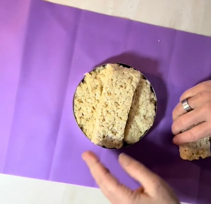 Shaping rice treats into a crown form in a cake tin