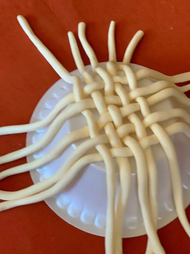 Woven modeling chocolate strips forming a basket pattern